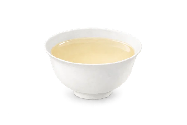 Small white porcelain tea cup with pale golden tea · 品茗杯